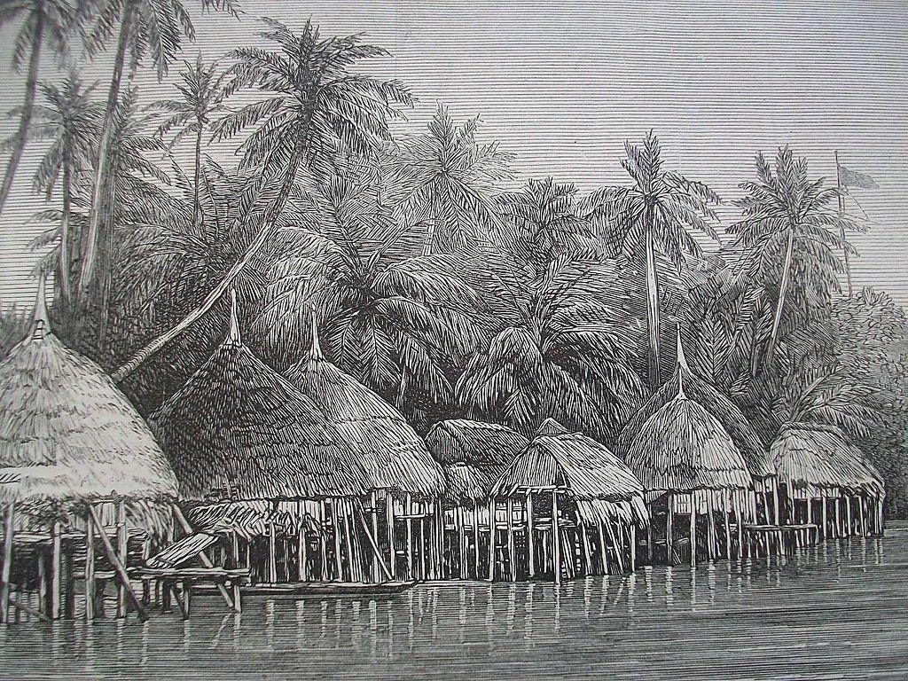 Hütten mit strohgedeckten Kuppeldächern auf Holzpfählen stehen im Wasser vor einem Wald mit Palmen.  © Wikimedia. 