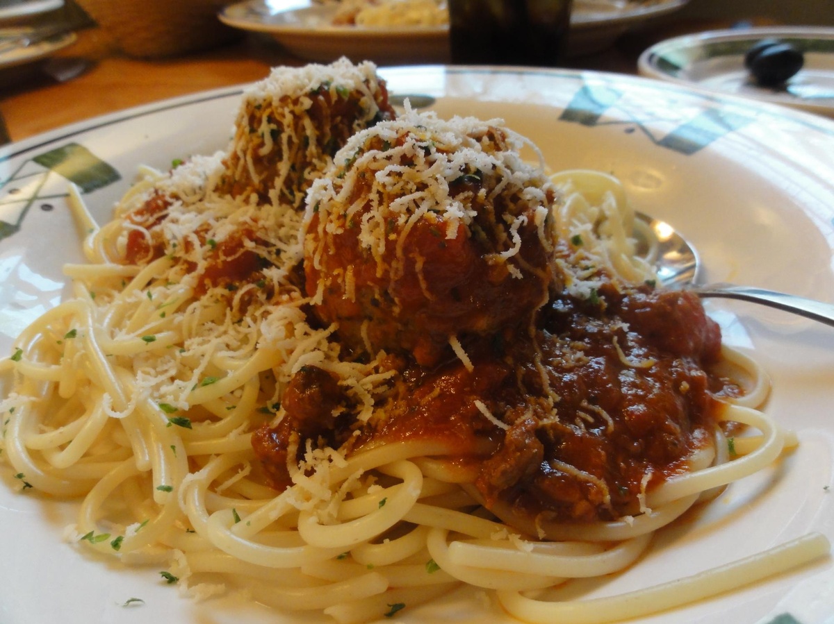 Auf einem Teller befindet sich eine Portion Spaghetti mit Fleischbällchen und rotbrauner Sauce. Obenauf wurde Parmesan gestreut. Daneben liegt ein Löffel.  © Wikimedia, Inazakira, CC-BY-SA-2.0. 