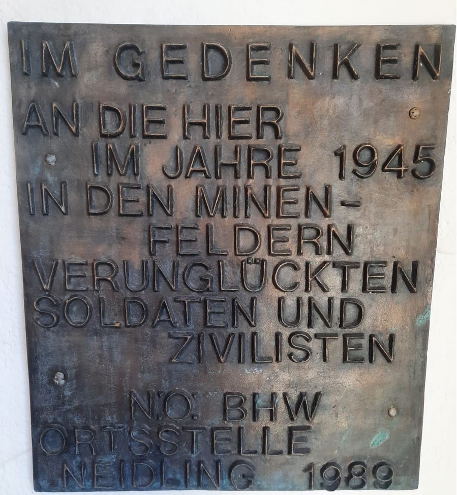 Auf einem bronzenen Schild steht der Text: „Im Gedenken an die hier im Jahre 1945 in den Minenfeldern verunglückten Soldaten und Zivilisten, N.Ö.: BHW, Ortsstelle Neidling 1989.“  © Doris Hössinger, Gedenktafel in der Kapelle Maria Bildbuche, Dunkelsteinerwald. 
