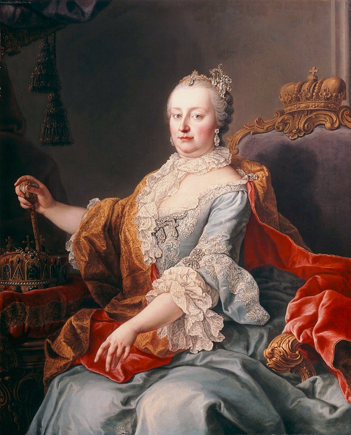 Das Portrait zeigt Maria Theresia als Herrscherin. Sie trägt aufwändiges Gewand mit wallenden Stoffen und Rüschen. Ihre grauen Haare sind zu einer Hochsteckfrisur zusammengefasst und mit Schmuck verziert.  © Wikimedia. 