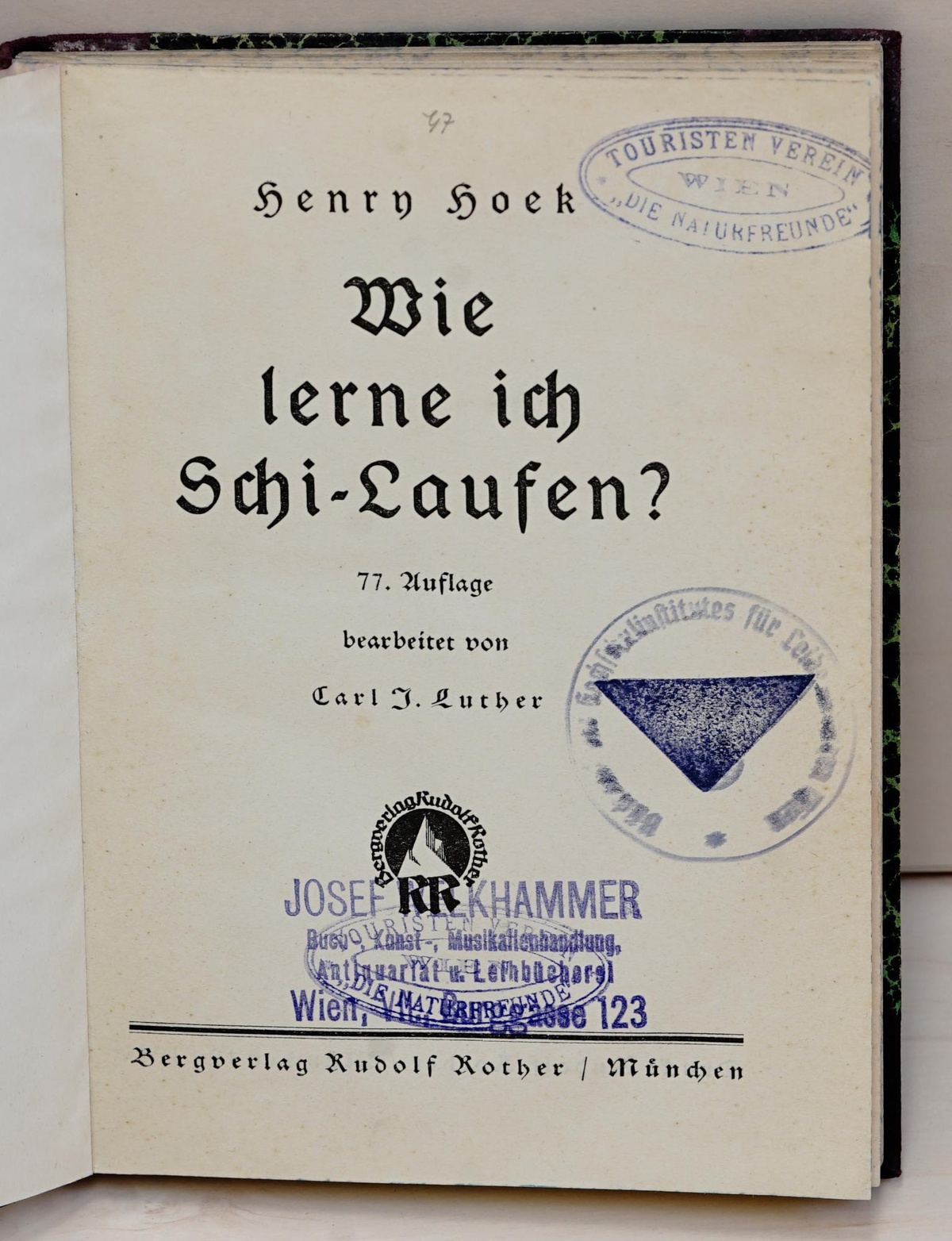 Alte Bücher mit zum Teil aufgeriebenen Kanten und Inventarnummern am Buchdeckel sind aufgereiht. Zwei Bücher im Vordergrund sind aufgeschlagen, Stempel sind sichtbar. Ein Titel lautet „Der Schilauf im Hochgebirge“, ein anderer „Wie lerne ich Schi-Laufen?“ © Marc Drews. 