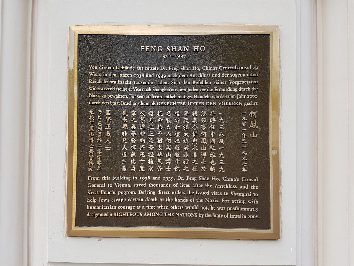 Das Bild zeigt eine graue Gedenktafel an einer Wand mit einem Text auf Deutsch, Chinesisch und Englisch. Der deutsche Text lautet: &bdquo;FENG SHAN HO 1901&ndash;1977 Von diesem Geb&auml;ude aus rettete Dr. Feng Shan Ho, Chinas Generalkonsul zu Wien, in den Jahren 1938 und 1939 nach dem Anschluss und der sogenannten Reichskristallnacht tausende Juden. Sich den Befehlen seiner Vorgesetzten widersetzend stellte er Visa nach Shanghai aus, um Juden vor der Ermordung durch die Nazis zu bewahren. F&uuml;r sein au&szlig;erordentlich mutiges Handeln wurde er im Jahr 2000 durch den Staat Israel posthum als GERECHTER UNTER DEN V&Ouml;LKERN geehrt.&ldquo; &copy; Wikimedia