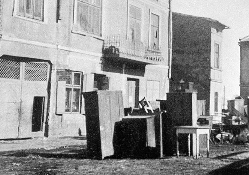 Schränke und ein Tischchen stehen vor einem Haus auf der Straße.  © Wikimedia, Möbel deportierter Juden und Jüdinnen stehen im Ghetto Mielec auf der Straße, 1942. 