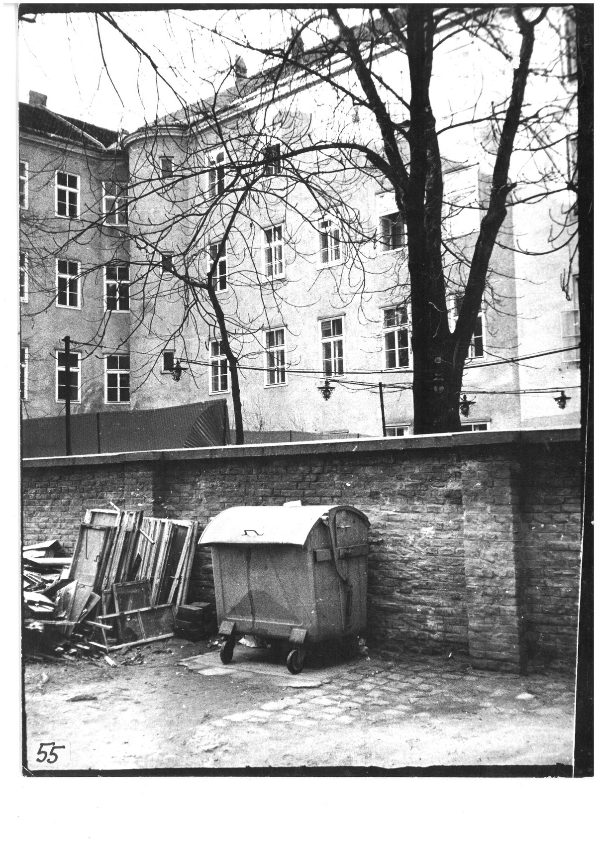 Das Schwarzwei&szlig;foto zeigt einen Innenhof, der durch eine Mauer zerteilt ist. Vor der Mauer befinden sich ein M&uuml;llcontainer und Sperrm&uuml;ll. Weiter hinten im Hof sind weitere Z&auml;une.  &copy; Gartenhofverein Planquadrat, Innenhof