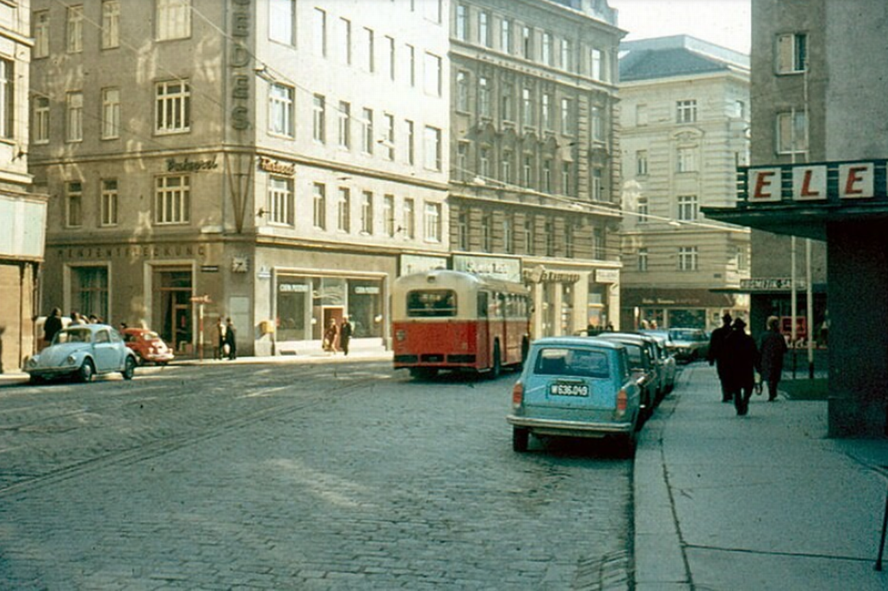 Straßenansicht in Wien mit einer kopfsteingepflasterten Straße, parkenden Autos am Straßenrand und einem Bus. Die Straße ist von mehrstöckigen Wohnhäusern gesäumt.  © Gustav Stehno, Wikimedia 