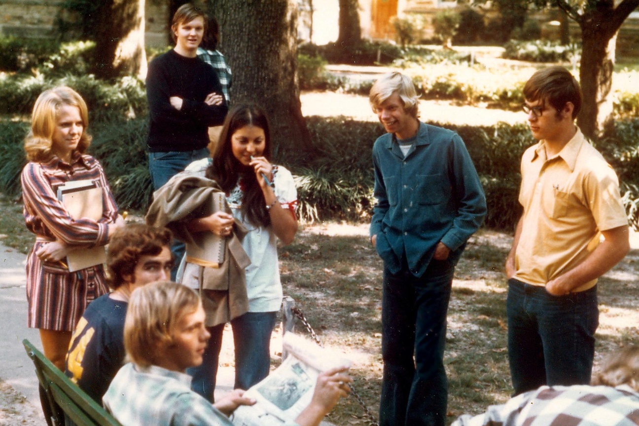 Einige Teenager stehen um eine Bank, zwei sitzen darauf. Im Hintergrund befindet sich ein Park. © Flickr, Ed Uthman, Rhodes College, 1970er. 