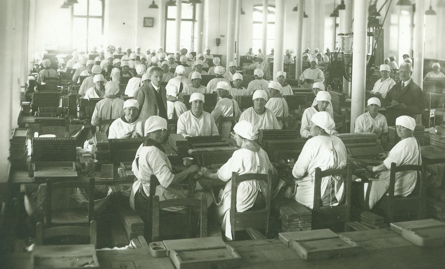 Arbeiterinnen der Tabakfabrik in weißer Berufskleidung an den Werkbänken. © Keltenmuseum Hallein/Stadtarchiv Hallein