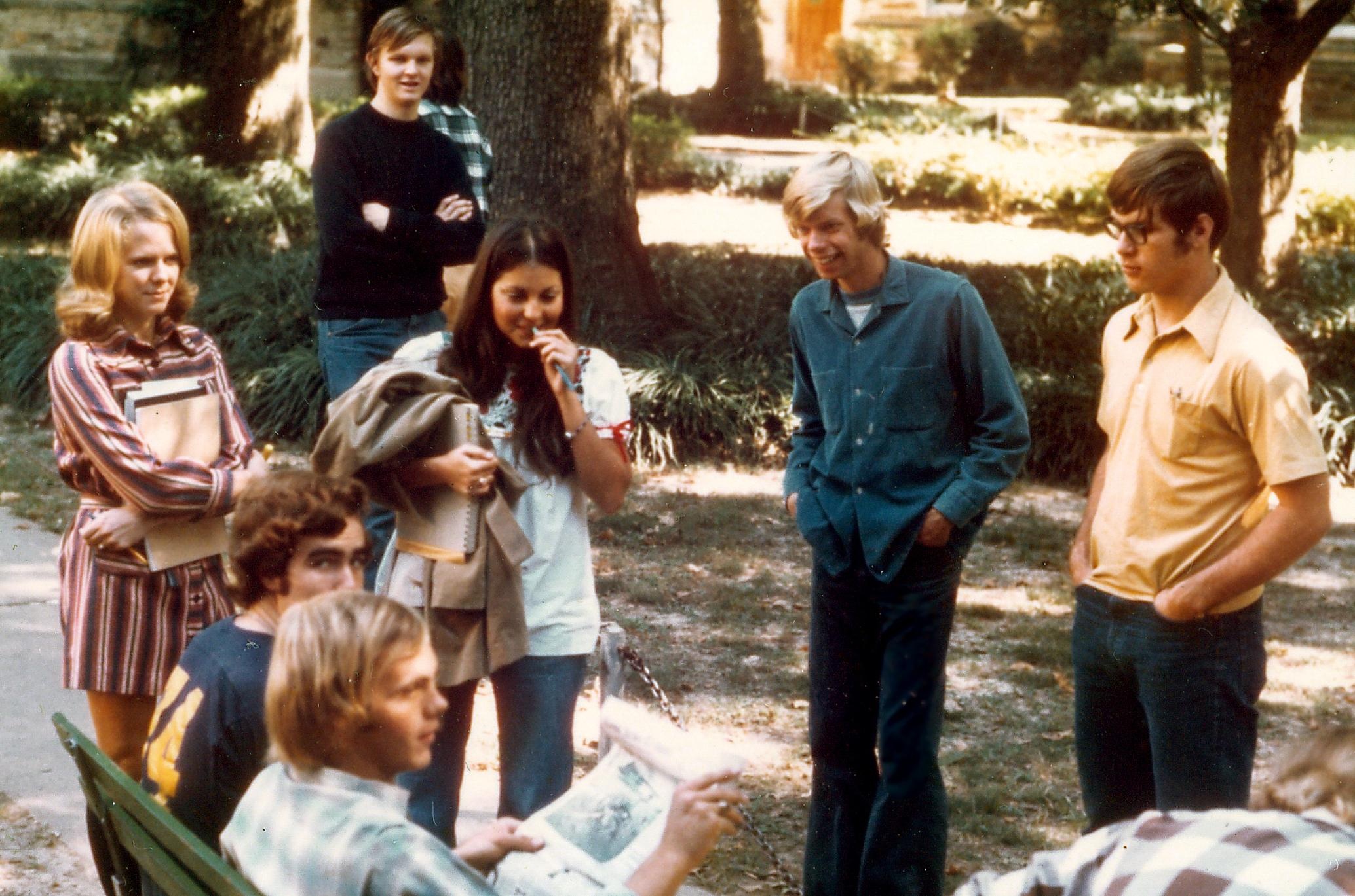 Einige Teenager stehen um eine Bank, zwei sitzen darauf. Im Hintergrund befindet sich ein Park. © Flickr, Ed Uthman, Rhodes College, 1970er. 
