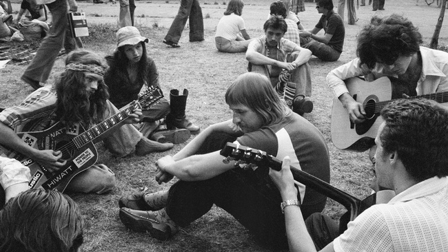 Junge Leute sitzen auf der Wiese und spielen Gitarre, während andere zuhören.  © Heinz Fiedler, Wien Museum; Besetzung der Arena. 