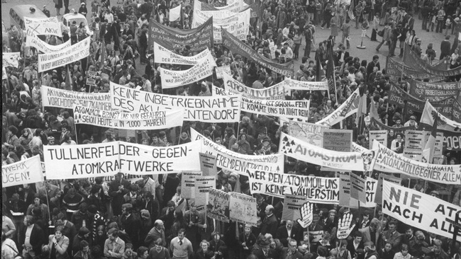Der ganze Platz ist voller Menschen, die dutzende unterschiedliche Banner hochhalten. Auf einem ganz vorne steht: Tullnerfelder gegen Atomkraftwerke. © ÖNB