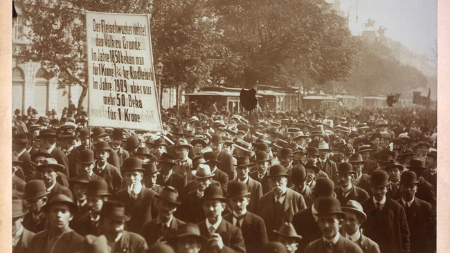 Eine große Menschenmenge demonstriert auf der Ringstraße gegen die Teuerung. Auf einem Plakat ist zu lesen: “Der Fleischwucher richtet das Volk zu Grunde.”  © ÖNB