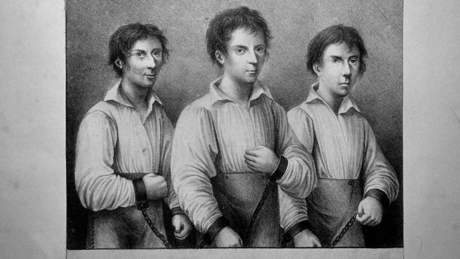 Die drei Räuber Jakob Fähding, Georg Grasel und Iganz Stangel stehen nebeneinander. Alle drei sind mit Handschellen angekettet. © Wikipedia