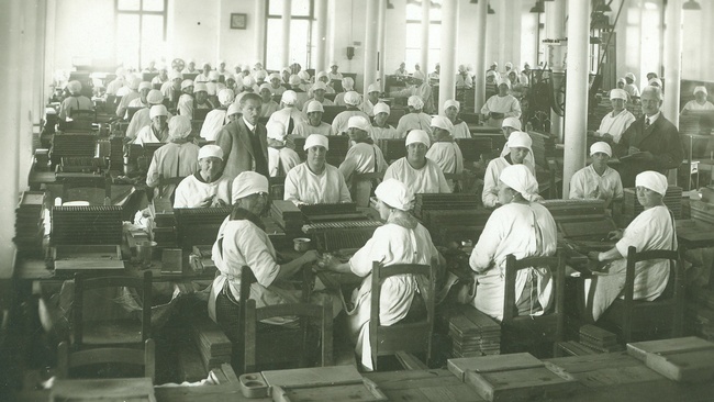 Arbeiterinnen der Tabakfabrik in weißer Berufskleidung an den Werkbänken. © Keltenmuseum Hallein/Stadtarchiv Hallein