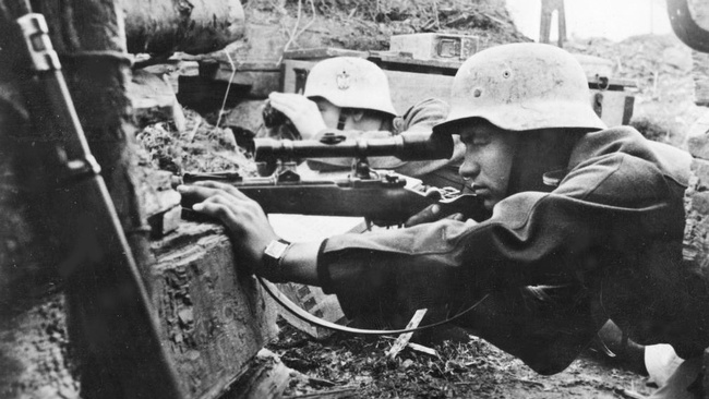 Zwei junge Soldaten in Uniform, mit Helm und Maschinengewehr in einem Schützengraben.  © Wikimedia