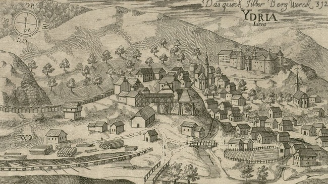 Zeichnung eines großen Bergwerks mit Holzlagerstätte und Förderschienen direkt in einem Dorf mit vielen Häusern, zwei Kirchen, Brücken, Feldern und einer Burg. Im Hintergrund Hügel, Berge und Bäume.  © Wikimedia