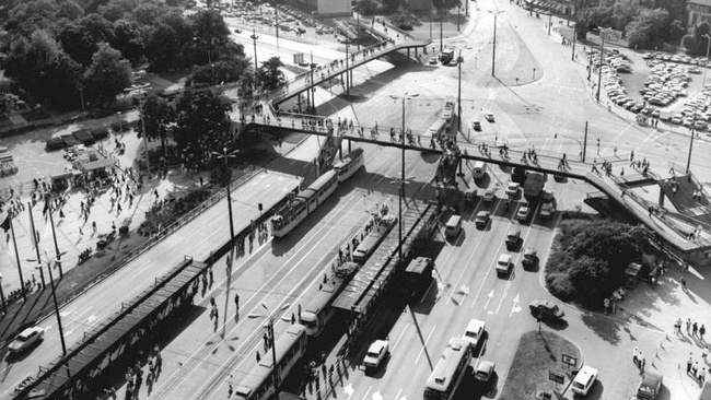Auf einem von oben fotografierten asphaltierten Platz fahren Autos und Straßenbahnen. Über den Platz führt eine Fußgängerbrücke. Es gibt kaum Vegetation.  © Wikimedia, Waltraud Grubitzsch, Bundesarchiv, CC-BY-SA 3.0. 
