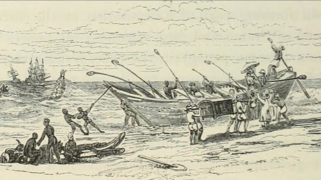 Ein Schiff erreicht die Küste und steht in den Wellen. Menschen mit Rudern und Seilen halten das Boot stabil, um die Passagiere aussteigen zu lassen. Am Strand befinden sich weitere Menschen. Am Horizont befinden sich auf dem Meer drei Segelboote mit mehreren Masten. Ein kleines indisches Boot nähert sich den viel größeren Segelbooten.  © Flickr. 