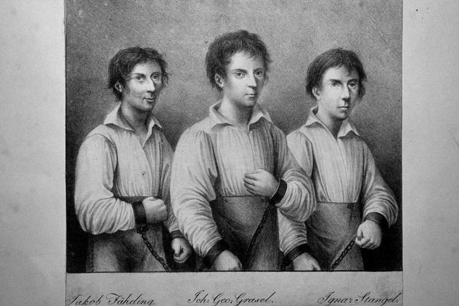Die drei Räuber Jakob Fähding, Georg Grasel und Iganz Stangel stehen nebeneinander. Alle drei sind mit Handschellen angekettet. © Wikipedia