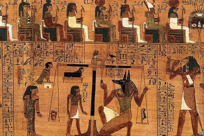 Zeichnung von ägyptischen Figuren und Tieren. In der Mitte Anubis und ein Mensch bei einer Waage, rechts ein adlerköpfiger Mensch, links zwei weiß gekleidete Figuren. Darüber Hieroglyphen und eine Reihe sitzender Figuren. © Wikimedia